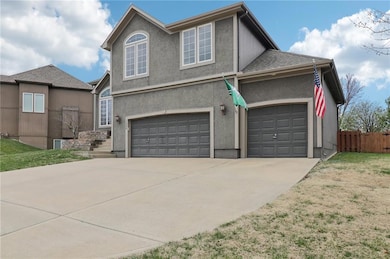 Traditional home with concrete driveway, stucco siding, roof with shingles, fence, and a garage
