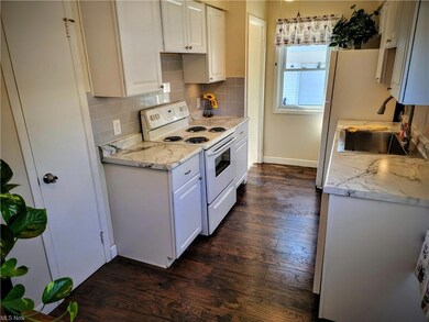 Kitchen featuring white cabinets, dark hardwood fl