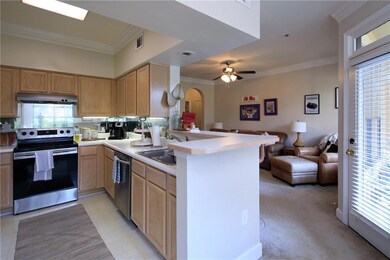 Kitchen featuring ornamental molding, appliances with stainless steel finishes, open floor plan, light countertops, and arched walkways