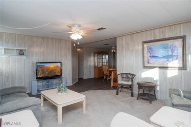 Living room with carpet floors, ceiling fan, and w