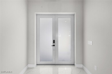 Entryway featuring marble finish floor and baseboa