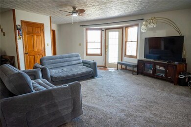 Living room with ceiling fan, carpet, and a textur