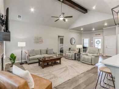 Living room with a stone fireplace, ceiling fan, h