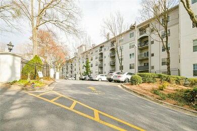 View of apartment building / complex featuring uncovered parking