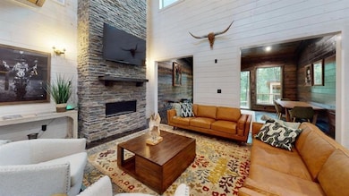 Living area with a high ceiling, wooden walls, and