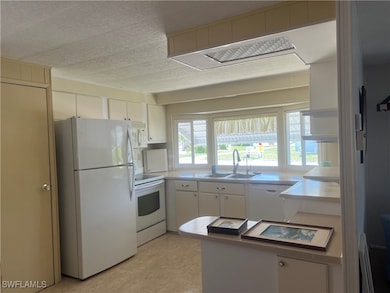 Kitchen with white appliances, a sink, white cabin