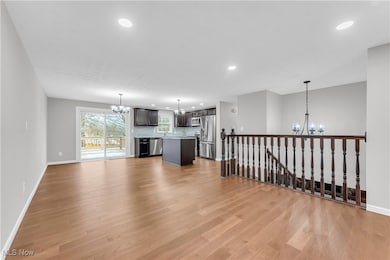 Unfurnished living room with an inviting chandelier and light hardwood / wood-style flooring