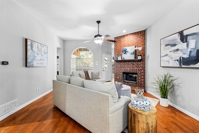 Living area featuring a brick fireplace, wood finished floors, ceiling fan, and recessed lighting