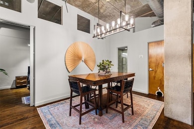 Dining room with dark wood-style flooring, a high ceiling, and a chandelier