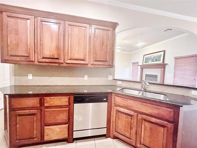 Kitchen featuring dark stone counters, white dishw
