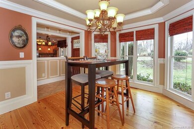 Window-wrapped dining room with heavy moldings