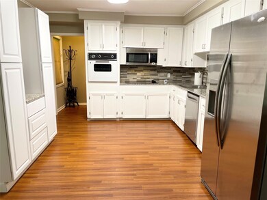 Kitchen featuring white cabinets, appliances with 
