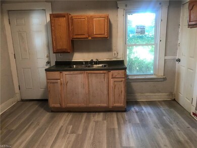 Kitchen featuring dark countertops, light hardwood floors, and brown cabinets