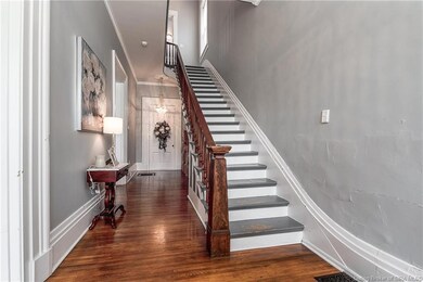 Entrance foyer leads to sweeping staircase with or