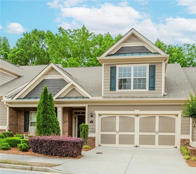 Craftsman-style house featuring roof with shingles, driveway, brick siding, and an attached garage