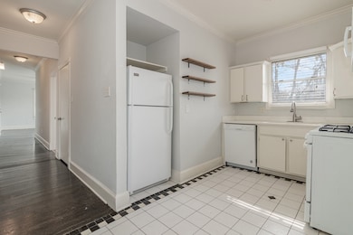 Kitchen featuring light countertops, white appliances, open shelves, crown molding, and light tile patterned floors