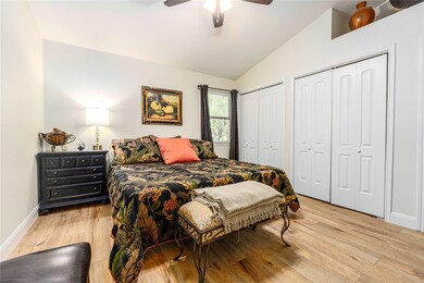 Bedroom with light wood-style flooring, vaulted c