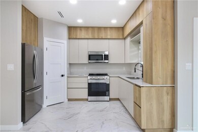 Kitchen with stainless steel appliances, modern cabinets, light marble finish flooring, recessed lighting, and light stone counters