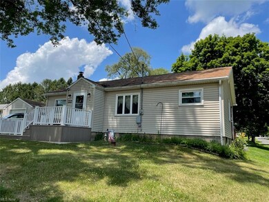 Front view of property featuring a lawn and a deck