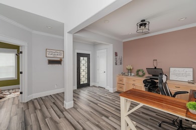 The entryway leads to the dining room (currently being used as a workspace) that features built-in cabinets convenient to house place settings and to use as a serving space.