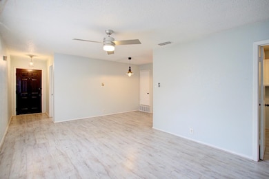 Unfurnished room featuring ceiling fan, light wood-type flooring, and a textured ceiling