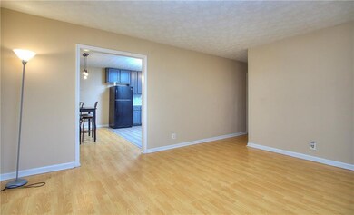 Spare room with light wood finished floors, baseboards, and a textured ceiling