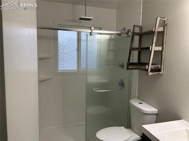 Full bath with a shower stall, toilet, and vanity