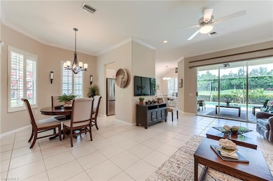 Dining space featuring a chandelier, healthy amount of natural light, crown molding, a ceiling fan, and light tile patterned floors