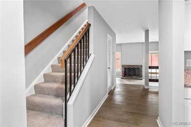 Stairs with wood-type flooring and a brick firepla