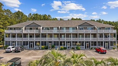 View of apartment building / complex with uncovered parking