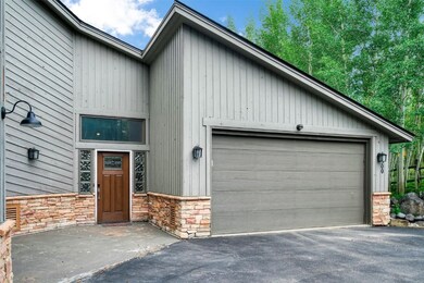 View of front of house with stone siding and drive