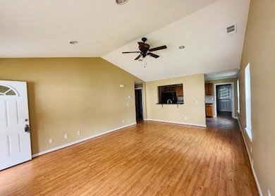 Unfurnished living room with lofted ceiling, light wood finished floors, and a ceiling fan