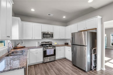 Kitchen featuring sink, white cabinets, stainless 