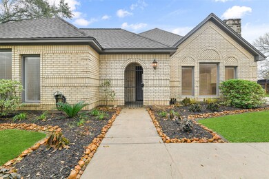 Rock-lined landscape beds line the paved pathway from the double-wide driveway to the gated courtyard of this one-of-a-kind home with a creamy brick elevation, double-paned windows, a post-tension foundation, and a roof that was replaced in 2008.