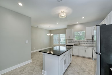 Kitchen with light tile patterned floors, stainle