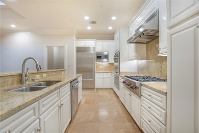 Kitchen with tasteful backsplash, light stone coun