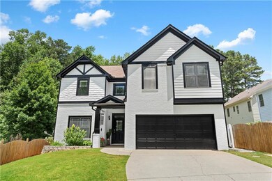 View of front of home with concrete driveway, an attached garage, and stucco siding