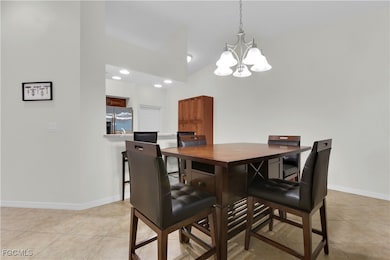 Dining area with light tile patterned floors, recessed lighting, and a chandelier
