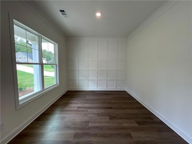 Empty room featuring crown molding, dark wood-style flooring, and recessed lighting