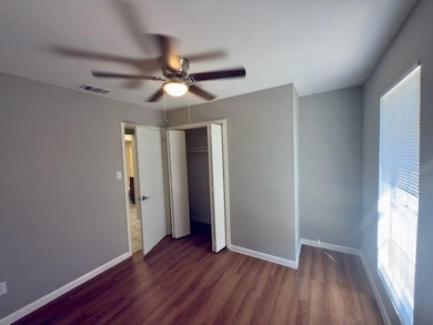Unfurnished bedroom featuring dark wood-style flooring, ceiling fan, and a closet