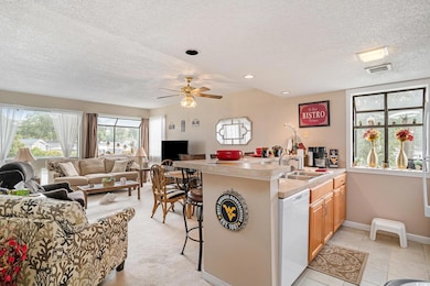 Kitchen featuring a peninsula, a breakfast bar area, light countertops, a textured ceiling, and dishwasher