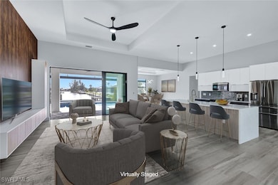 Living room featuring a ceiling fan, light wood-st
