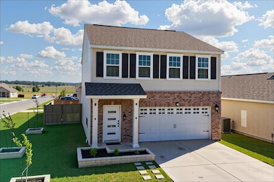 Traditional-style home with brick siding, roof with shingles, driveway, and a garage
