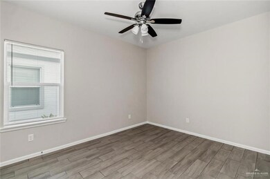 Empty room featuring light wood-style floors, plenty of natural light, and ceiling fan