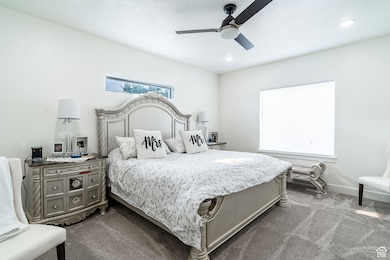 Bedroom featuring dark colored carpet and a ceiling fan