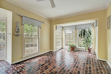 Den with brick paver flooring and views to backyard.