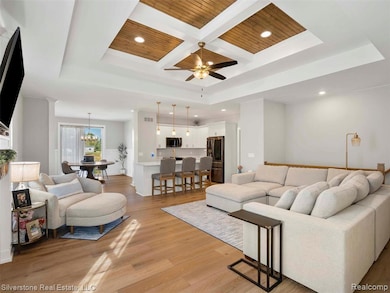 Living room featuring coffered ceiling, light wood-type flooring, recessed lighting, a wooden ceiling with exposed beams, and ceiling fan