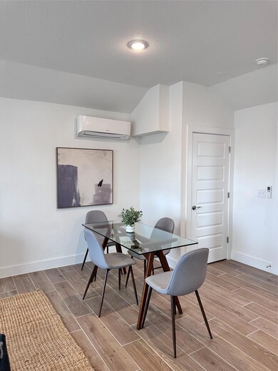 Dining area featuring a wall mounted AC, wood til