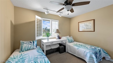 Carpeted bedroom featuring rail lighting, a textur