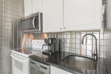 Kitchen with decorative backsplash, sink, white ra